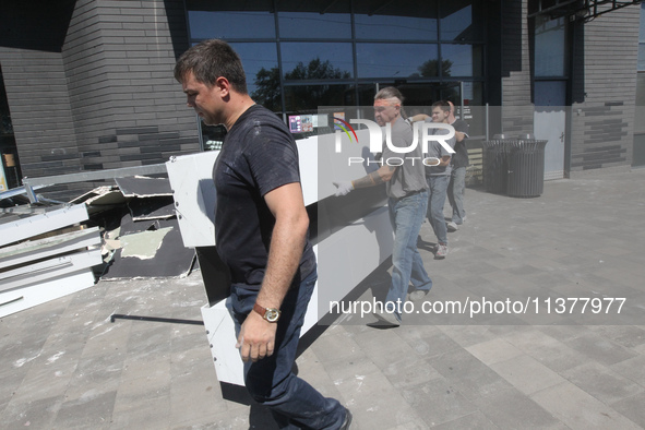 Men are carrying damaged items out of a supermarket affected by a recent Russian missile attack in Dnipro, Ukraine, on July 1, 2024. Russia...