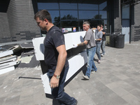 Men are carrying damaged items out of a supermarket affected by a recent Russian missile attack in Dnipro, Ukraine, on July 1, 2024. Russia...