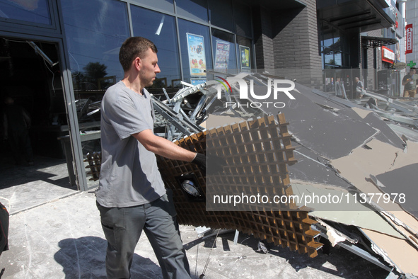 A man is carrying a damaged item out of a supermarket affected by a recent Russian missile attack in Dnipro, Ukraine, on July 1, 2024. Russi...