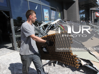 A man is carrying a damaged item out of a supermarket affected by a recent Russian missile attack in Dnipro, Ukraine, on July 1, 2024. Russi...