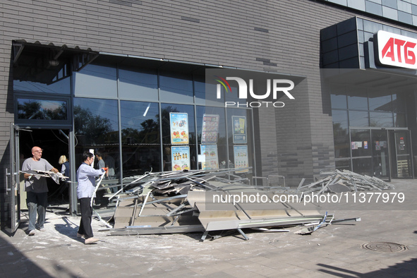 Men are carrying damaged items out of a supermarket affected by a recent Russian missile attack in Dnipro, Ukraine, on July 1, 2024. Russia...