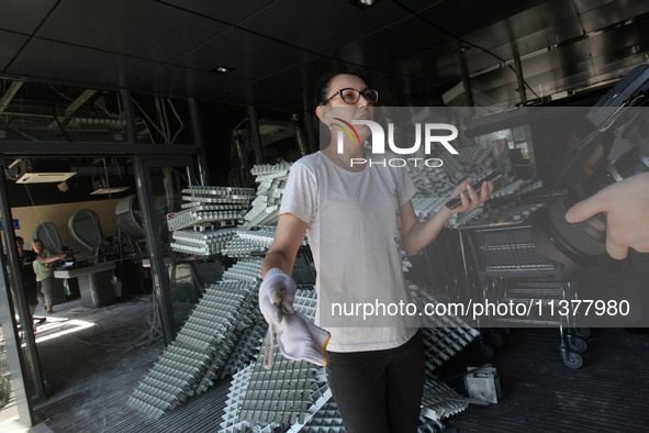 A woman is removing the debris from a supermarket damaged by a recent Russian missile attack and is speaking to the press in Dnipro, Ukraine...