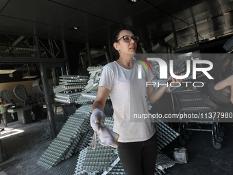 A woman is removing the debris from a supermarket damaged by a recent Russian missile attack and is speaking to the press in Dnipro, Ukraine...