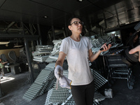 A woman is removing the debris from a supermarket damaged by a recent Russian missile attack and is speaking to the press in Dnipro, Ukraine...