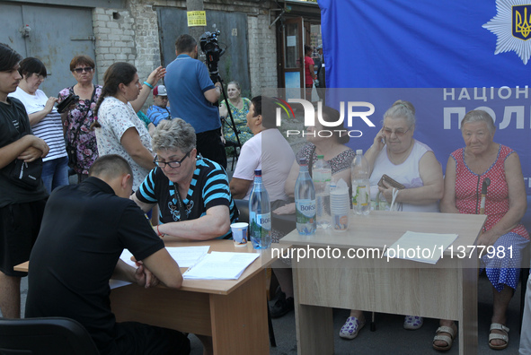 A police officer is helping a woman affected by a recent Russian missile attack at a coordination headquarters in Dnipro, Ukraine, on July 1...