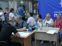 A police officer is helping a woman affected by a recent Russian missile attack at a coordination headquarters in Dnipro, Ukraine, on July 1...