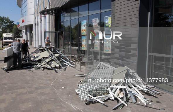 Men are carrying damaged items out of a supermarket affected by a recent Russian missile attack in Dnipro, Ukraine, on July 1, 2024. Russia...