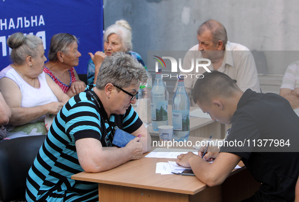 A police officer is helping a woman affected by a recent Russian missile attack at a coordination headquarters in Dnipro, Ukraine, on July 1...