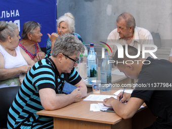 A police officer is helping a woman affected by a recent Russian missile attack at a coordination headquarters in Dnipro, Ukraine, on July 1...