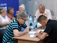 A police officer is helping a woman affected by a recent Russian missile attack at a coordination headquarters in Dnipro, Ukraine, on July 1...