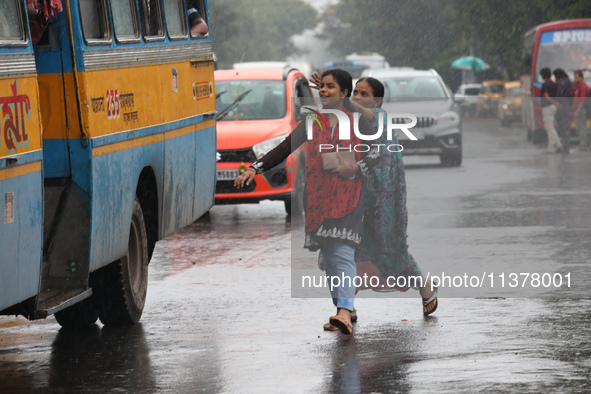 Commuters are trying to get on the passenger bus on a busy road during monsoon rain in Kolkata, India, on July 2, 2024. 