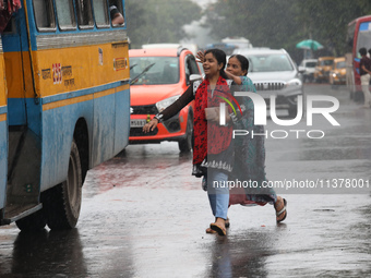 Commuters are trying to get on the passenger bus on a busy road during monsoon rain in Kolkata, India, on July 2, 2024. (