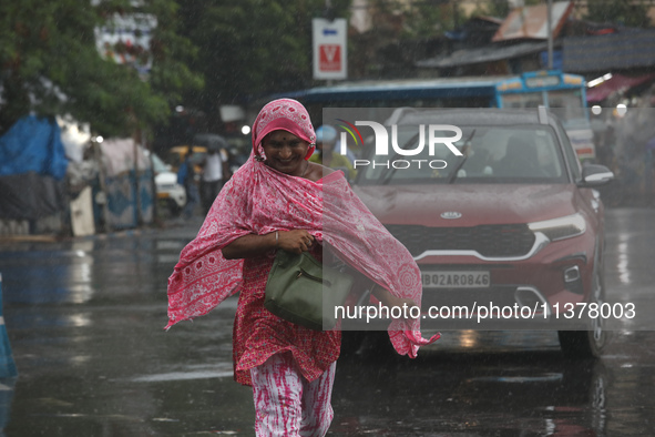 A woman is crossing a busy road during monsoon rain in Kolkata, India, on July 2, 2024. 