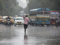 A man is crossing a busy road during monsoon rain in Kolkata, India, on July 2, 2024. (