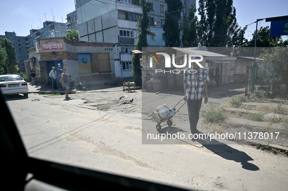 Locals are being pictured in the street in the rural settlement of Stepnohirsk that is being shelled daily by Russian troops as the team of...