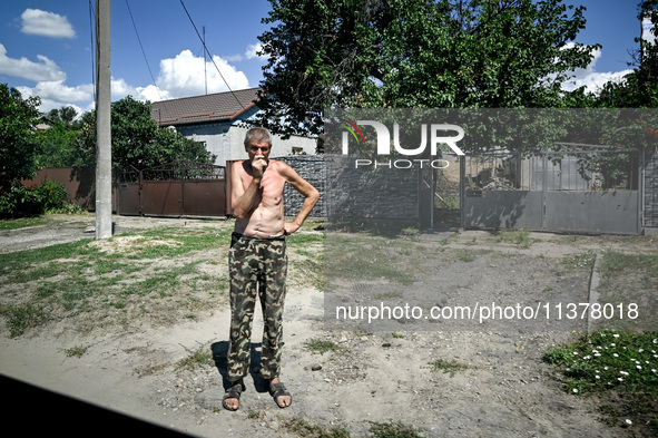 A local is standing in the street in the rural settlement of Stepnohirsk, which is being shelled daily by Russian troops, as the team of Zap...