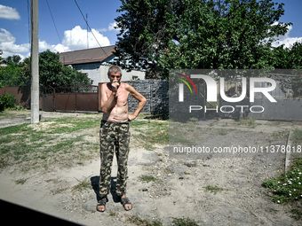 A local is standing in the street in the rural settlement of Stepnohirsk, which is being shelled daily by Russian troops, as the team of Zap...