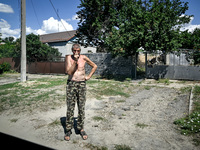 A local is standing in the street in the rural settlement of Stepnohirsk, which is being shelled daily by Russian troops, as the team of Zap...