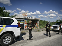 Police officers from an evacuation group are putting on personal protective equipment on their way to the rural settlement of Stepnohirsk th...