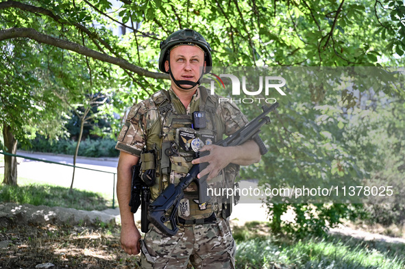 A community police officer is holding a rifle in the street in the rural settlement of Stepnohirsk, Ukraine, on June 28, 2024, which is bein...