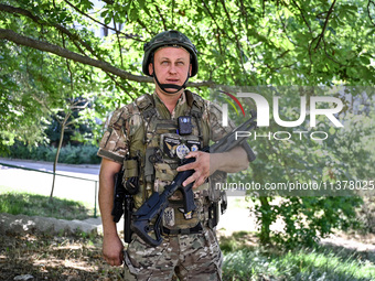 A community police officer is holding a rifle in the street in the rural settlement of Stepnohirsk, Ukraine, on June 28, 2024, which is bein...