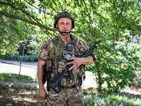 A community police officer is holding a rifle in the street in the rural settlement of Stepnohirsk, Ukraine, on June 28, 2024, which is bein...