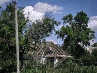 A man is repairing the roof of a house in the rural settlement of Stepnohirsk, Ukraine, on June 28, 2024, as the team of Zaporizhzhia police...