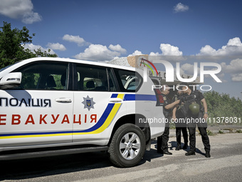 Police officers from an evacuation group are putting on personal protective equipment on their way to the rural settlement of Stepnohirsk th...