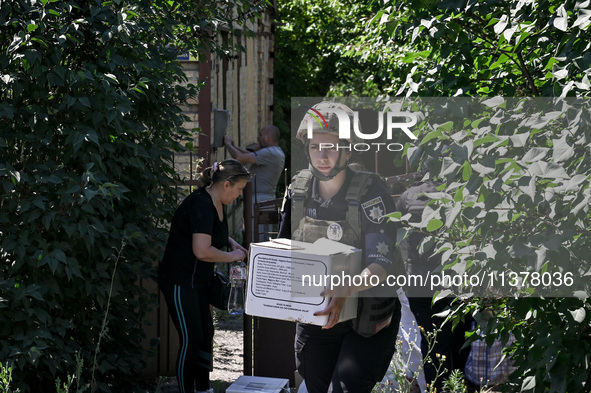 A police officer is helping local Iryna during the evacuation from the rural settlement of Stepnohirsk that is being shelled daily by Russia...