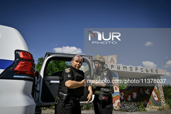 Police officers from an evacuation group are putting on personal protective equipment on their way to the rural settlement of Stepnohirsk th...