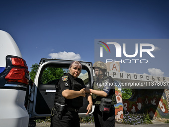 Police officers from an evacuation group are putting on personal protective equipment on their way to the rural settlement of Stepnohirsk th...