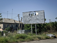 A hoarding dotted by shrapnel holes is being pictured in the rural settlement of Stepnohirsk that is being shelled daily by Russian troops a...