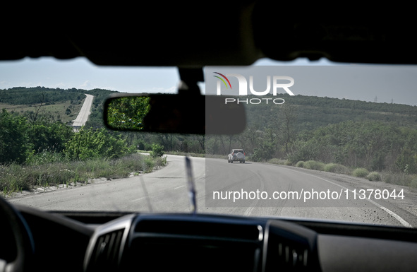 Members of an evacuation group are riding in a police car heading to the rural settlement of Stepnohirsk, which is shelled daily by Russian...