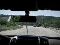 Members of an evacuation group are riding in a police car heading to the rural settlement of Stepnohirsk, which is shelled daily by Russian...