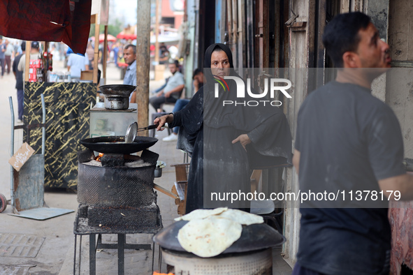 A displaced Palestinian woman is frying falafel at a stall in Deir el-Balah in the central Gaza Strip on July 2, 2024, amid the ongoing conf...