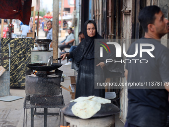 A displaced Palestinian woman is frying falafel at a stall in Deir el-Balah in the central Gaza Strip on July 2, 2024, amid the ongoing conf...