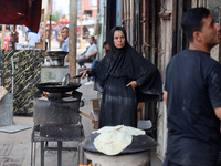 A displaced Palestinian woman is frying falafel at a stall in Deir el-Balah in the central Gaza Strip on July 2, 2024, amid the ongoing conf...