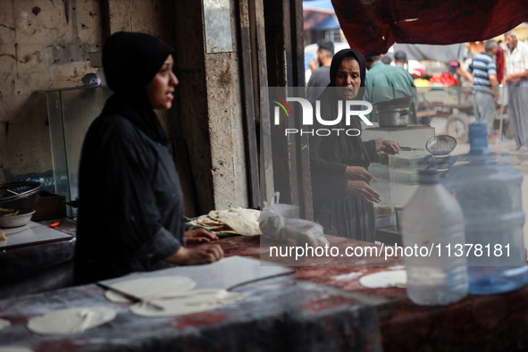 A displaced Palestinian woman is frying falafel at a stall in Deir el-Balah in the central Gaza Strip on July 2, 2024, amid the ongoing conf...