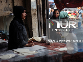 A displaced Palestinian woman is frying falafel at a stall in Deir el-Balah in the central Gaza Strip on July 2, 2024, amid the ongoing conf...