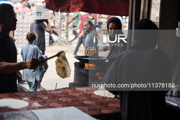 A displaced Palestinian woman is frying falafel at a stall in Deir el-Balah in the central Gaza Strip on July 2, 2024, amid the ongoing conf...