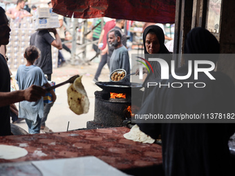 A displaced Palestinian woman is frying falafel at a stall in Deir el-Balah in the central Gaza Strip on July 2, 2024, amid the ongoing conf...