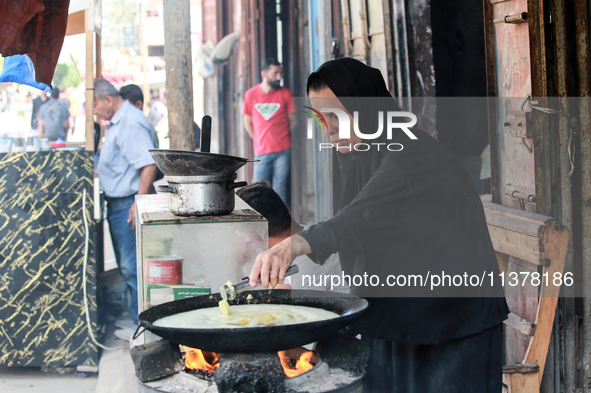 A displaced Palestinian woman is frying falafel at a stall in Deir el-Balah in the central Gaza Strip on July 2, 2024, amid the ongoing conf...