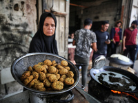 A displaced Palestinian woman is frying falafel at a stall in Deir el-Balah in the central Gaza Strip on July 2, 2024, amid the ongoing conf...