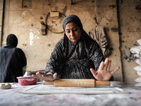 A displaced Palestinian woman is preparing flatbread dough at a stall kitchen in Deir el-Balah in the central Gaza Strip on July 2, 2024, am...