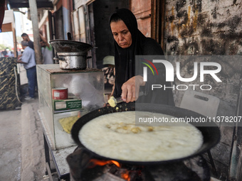 A displaced Palestinian woman is frying falafel at a stall in Deir el-Balah in the central Gaza Strip on July 2, 2024, amid the ongoing conf...