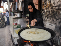 A displaced Palestinian woman is frying falafel at a stall in Deir el-Balah in the central Gaza Strip on July 2, 2024, amid the ongoing conf...