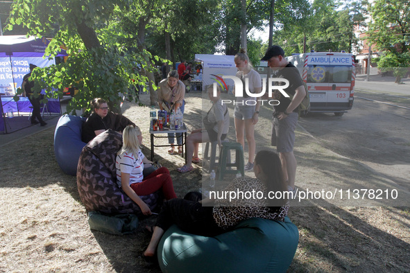 Residents are staying outside the apartment block hit by a Russian missile on June 28 during a response effort in Dnipro, Ukraine, on June 3...