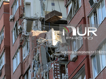 A crane and container are being used to remove the rubble at the apartment block hit by a Russian missile in Dnipro, Ukraine, on June 30, 20...