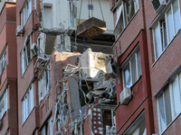 A crane and container are being used to remove the rubble at the apartment block hit by a Russian missile in Dnipro, Ukraine, on June 30, 20...