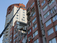 A crane and container are being used to remove the rubble at the apartment block hit by a Russian missile in Dnipro, Ukraine, on June 30, 20...